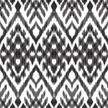 Vector illustration of the black and white colored ikat ornamental seamless pattern. Scribble texture. Chevron design.