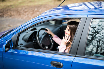 woman using smartphone while driving car