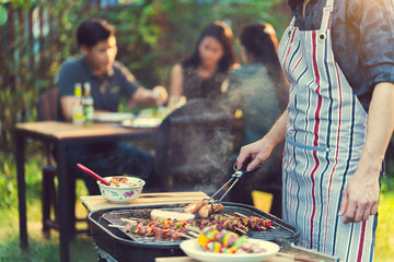 Asian men are cooking for a group of friends to eat barbecue - obrazy, fototapety, plakaty