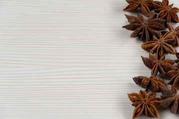 Star anise on white wooden background.