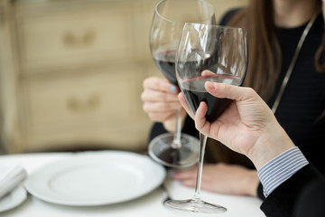 Beautiful young couple with glasses of red wine in luxury restaurant