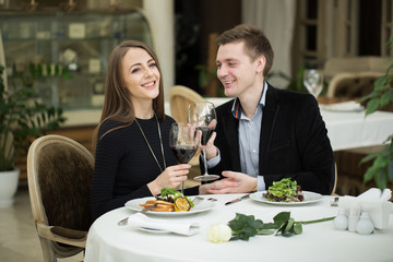 Happy couple in restaurant, enjoying the wine and salad