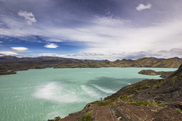 shore of blue lake and clouded sky in patagonia at daylight