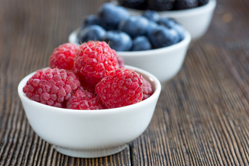 Fresh berries in bowls on a rustic wooden table