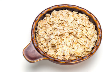 Dry rolled oat flakes oatmeal in a old bowl