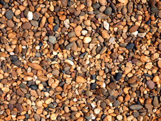 Pebble ground pattern, orange gravel floor material, brown soil surface, natural garden land backdrop, tan stone wall background, marble rock soil texture