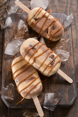 Homemade caramel chocolate popsicles with candy