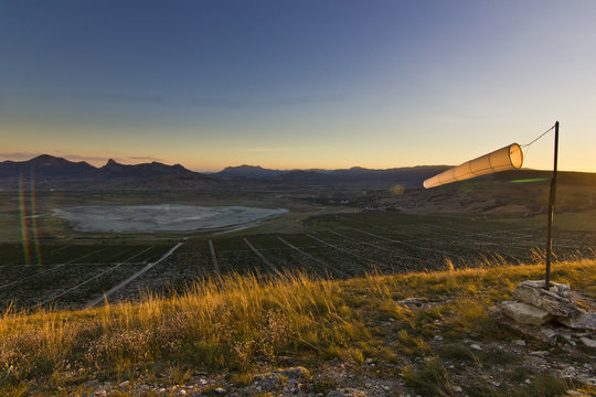 windsock at sunset in mountains against sun