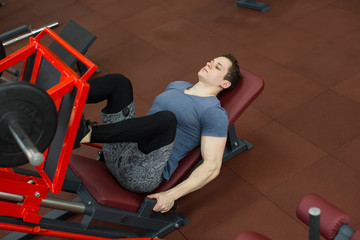 Fototapeta na wymiar Attractive Young Man Doing Leg Press On Machine In Gym.
