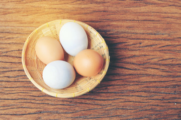 Eggs in basket with old beautiful wooden background.