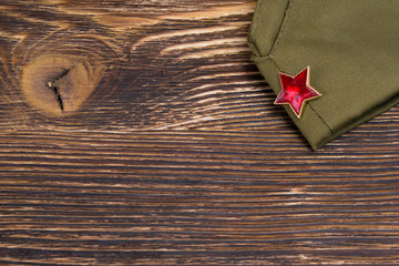 Military cap on a wooden table and place for an inscription