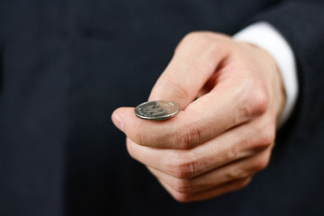 Businessman tossing a coin. Heads or tails. Close up