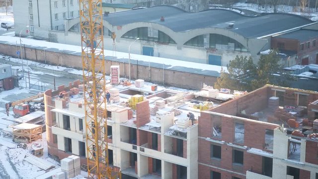 Construction crane loads construction bricks, workers help. 4k, 3840x2160