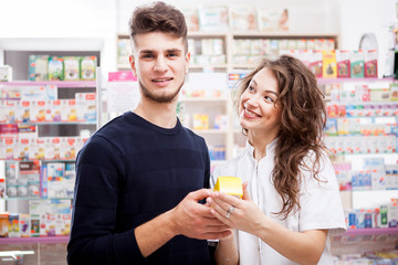 Pharmacist woman and client in front of the shop. Healthcare business