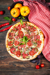 delicious pizza, vegetables and spices on wooden table