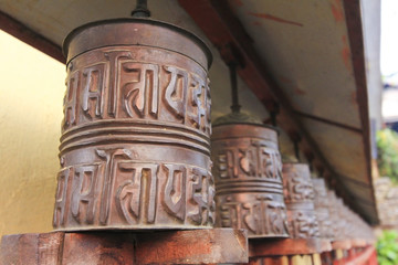 Obraz premium Metal prayer wheels for meditation and praying, from Buddhism Tibetan monastery in countryside of Nepal