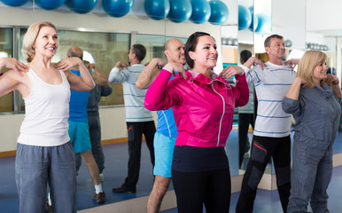 Group of adults doing aerobics exercise in  sport club