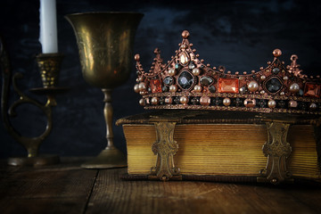 low key image of beautiful queen/king crown on old book