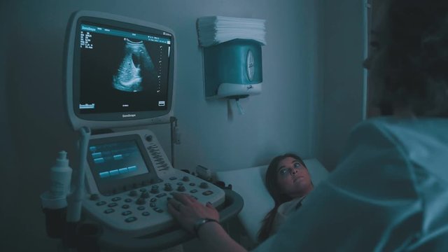Closeup of woman getting an ultrasound scan on abdominal by doctor. Screen of echo-cardiography (ultrasound) machine. Medical Equipment ultrasound scanning. Echo machine, ultrasound machine.