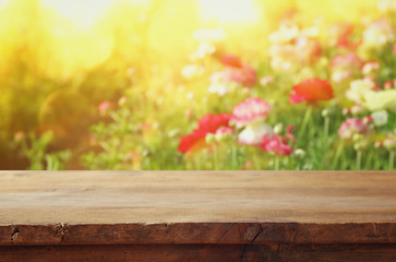 wooden board table in front of summer flowers field