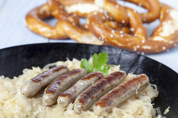 Nürnberger Bratwurst auf Kraut in einer Pfanne