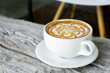 cup of coffee latte art with caramel on wood table