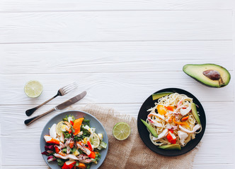 salad and pasta with seafood on wooden background 