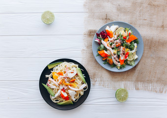 salad and pasta with seafood on wooden background 