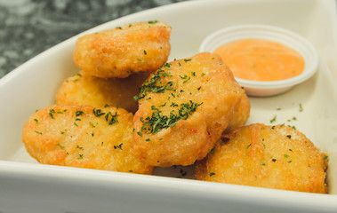 Close up of Crispy chicken nuggets with sauce.