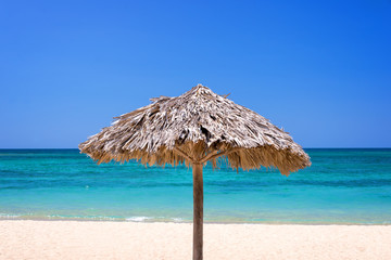 Straw umbrella on a beautiful tropical beach