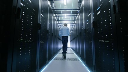 Server Engineer in Data Center Walks Through Sliding Doors and Opens Server Rack Cabinet.  Shot on RED EPIC-W 8K Helium Cinema Camera. - Powered by Adobe