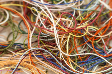 Multi-colored tangled colorful needlecraft silk thread rope. Macro shot. Abstract colors background