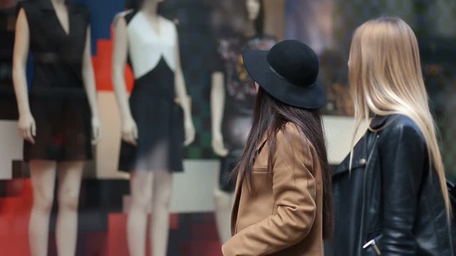 Shopping women looking at clothing store window