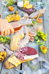 Fototapeta na wymiar Picnic with rose wine fruits meat and cheese