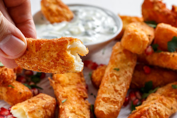 Crispy Halloumi cheese sticks Fries with yogurt for dipping and pomegranate seeds.