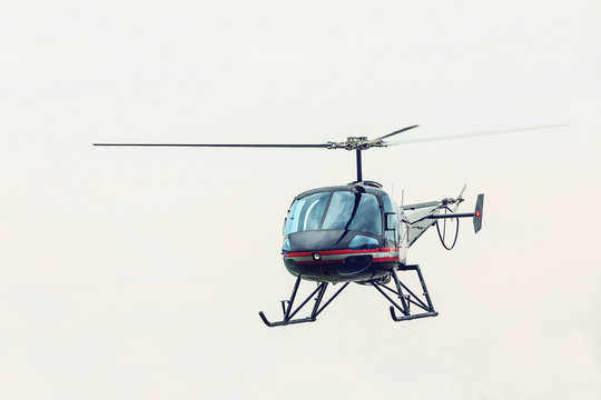 Black helicopter flying in front. Light multipurpose helicopter five-seat all-metal construction.