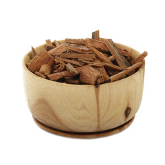 cinnamon (cassia) in wooden cup isolated on white background