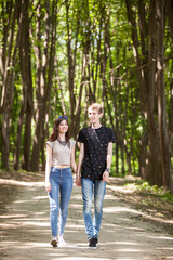 Fototapeta premium Couple taking a walk in the forest. Lifestyle and relationship. Young inlove boyfriend and girlfriend