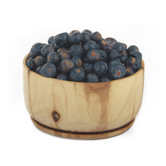 juniper berries  in wooden cup isolated