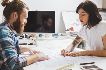 People with blueprints at workplace