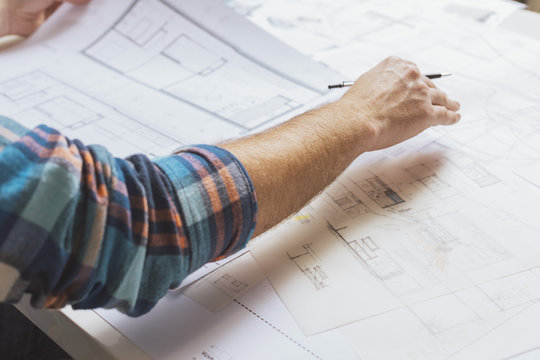 Hand of architect working with plans