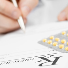 Medicine, healthcare and all things related - doctor signing out prescription with pills over it