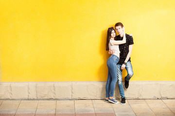 Obraz na płótnie Canvas Inlove couple posing in fashion style on yellow wall. Lifestyle and relationship