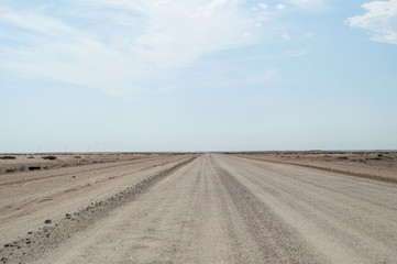 Fototapeta na wymiar Endless Dirt Road in the Desert between Walvis Bay and Solitaire in Namibia