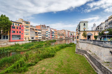 Fototapeta premium Cloudy view of riverside and bridge over river Onyar, Girona, Catalonia, Spain.