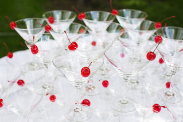 Close-up of the champagne pyramid with a red cherry at the top of each glassGlass goblets. Pyramid of champagne. A celebratory drink. Decorations for the Banquet.