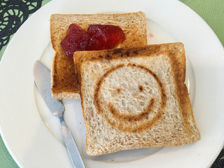 Toasted slice of bread with jam on white plate