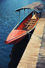Obraz premium Boat in sun light at pier on lake