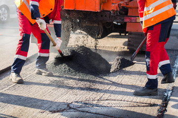 Young builder on Asphalting paver machine during Road street repairing works