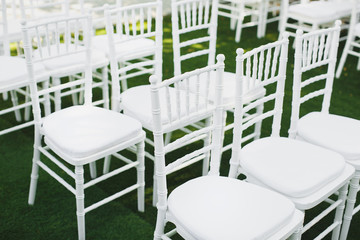 Beautiful white wedding chairs at the ceremony in the Park.
